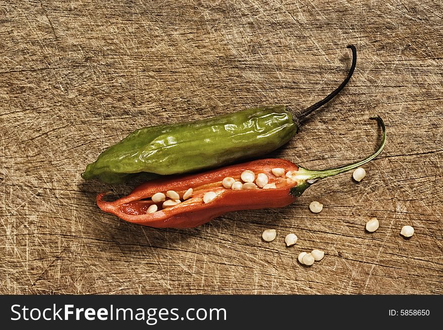 Two chili peppers on a cutting table. Two chili peppers on a cutting table.