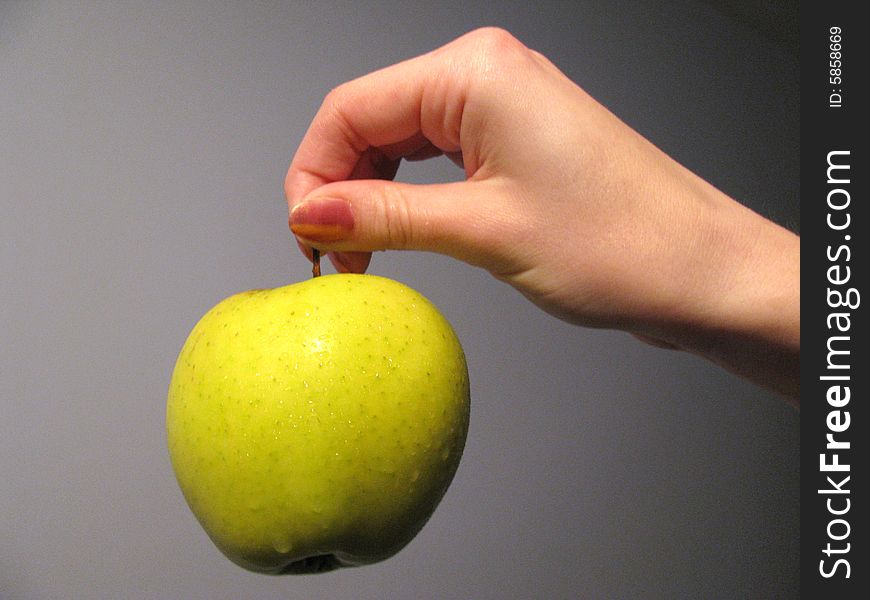 The hand with juicy green apple