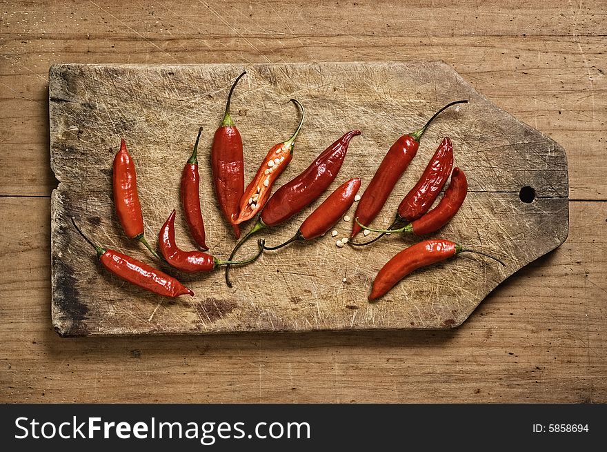 Red chili peppers on a cutting table. Red chili peppers on a cutting table.