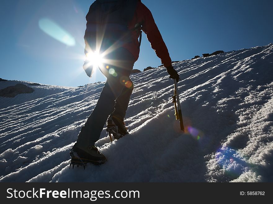 Lone male mountain climber climbing a snowy ridge; Mont Blanc, Europe.