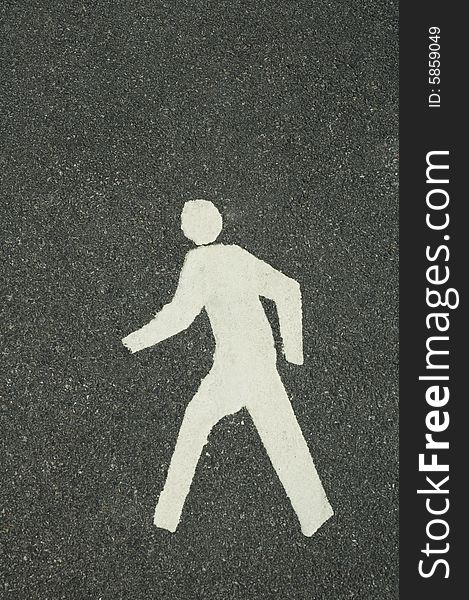 White footpath symbol of walking man, grey asphalt background