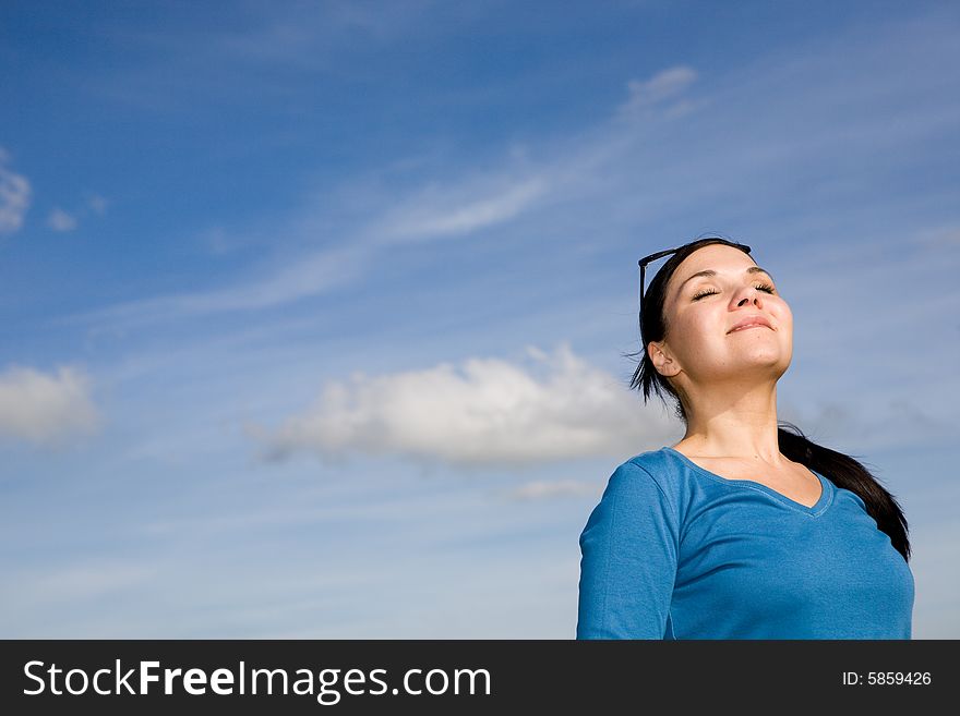 Attractive brunette woman relaxing on sky background. Attractive brunette woman relaxing on sky background