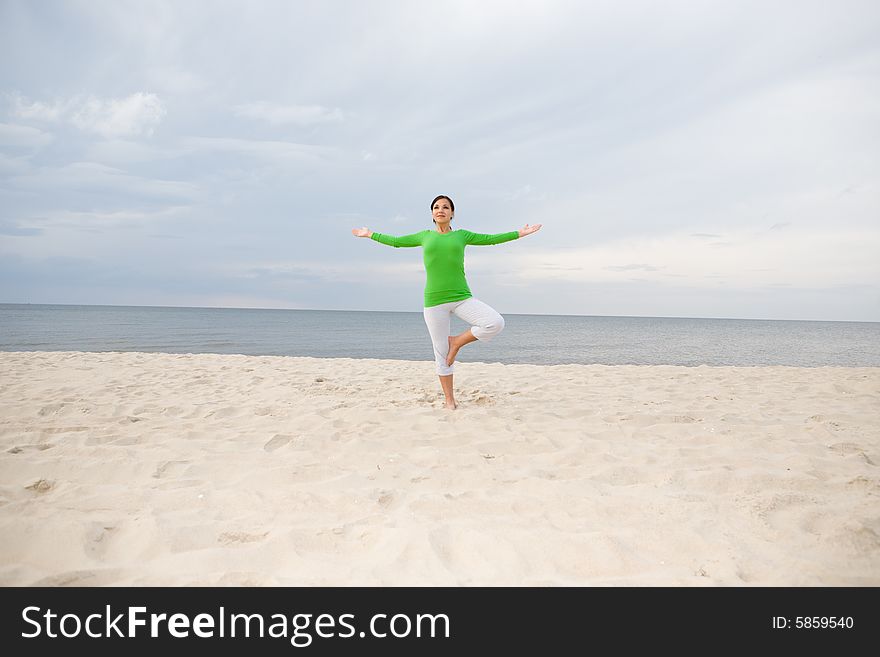 Attractive woman doing exercise on the beach