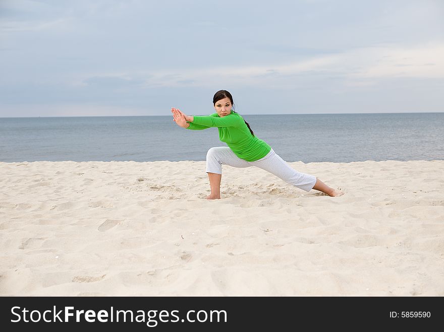 Attractive woman doing exercise on the beach
