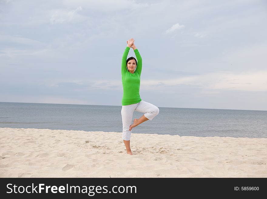 Attractive woman doing exercise on the beach