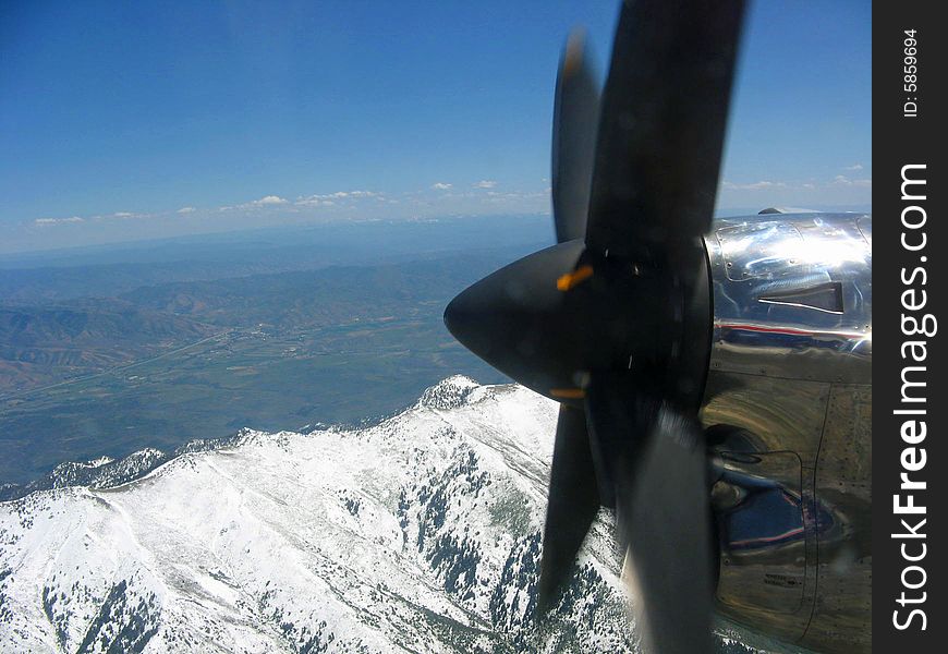 Looking past an airplane propeller to snow covered mountains. Looking past an airplane propeller to snow covered mountains.