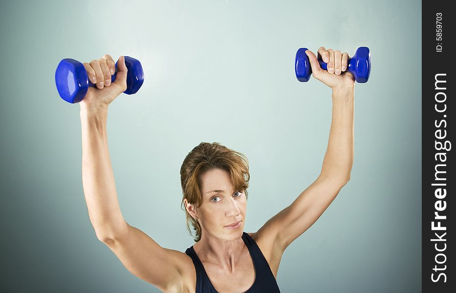 Pretty athletic woman working out with dumbbells. Pretty athletic woman working out with dumbbells
