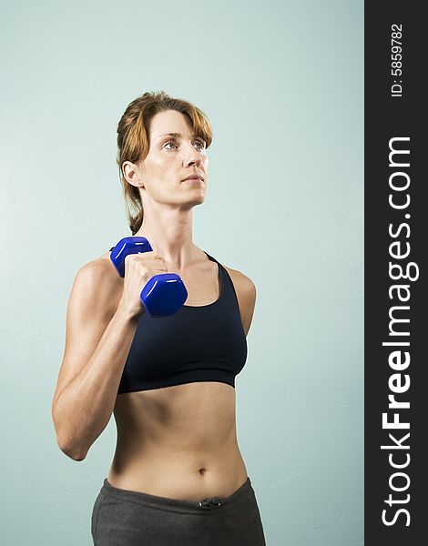 Pretty athletic woman working out with dumbbells. Pretty athletic woman working out with dumbbells