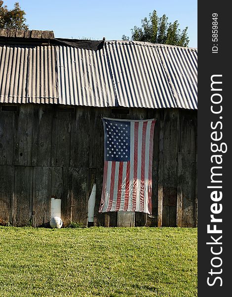American flag hung on side of an old barn