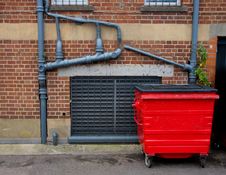 Red Garbage Bin And Outside Sewer Pipes Stock Images Red Garbage Bin And Outside Sewer Pipes Stock Images