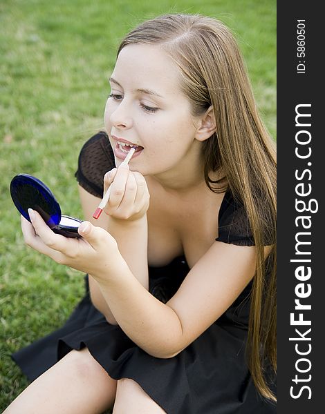 Girl doing makeup in park