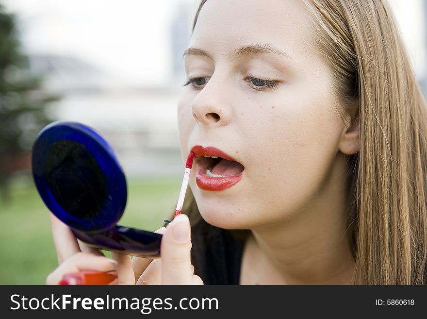 Girl doing makeup in city