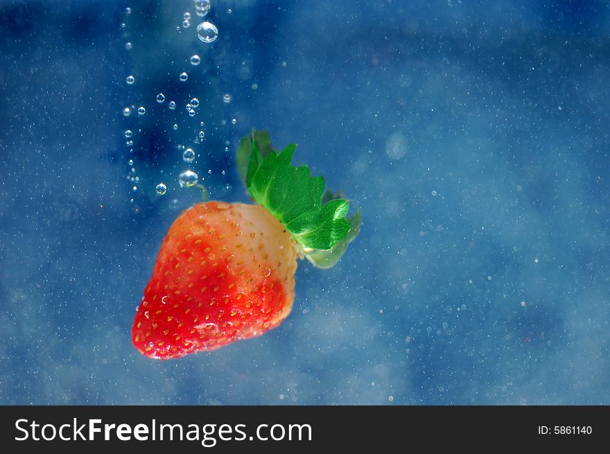 Single strawberrien splashing into water. Single strawberrien splashing into water