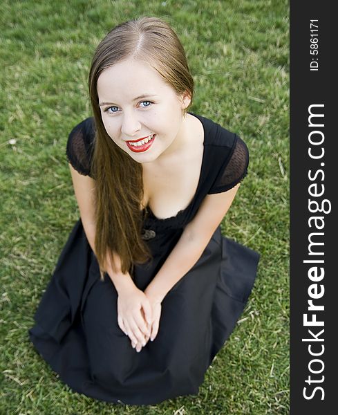 Smiling girl with red lips on green grass