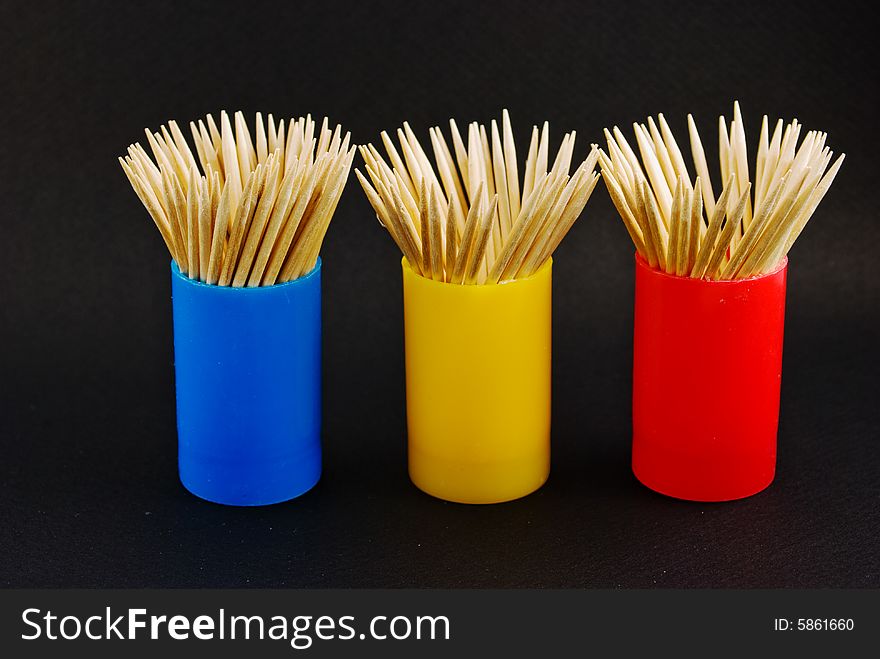 Colorful toothpick containers in three colors against a black background. Colorful toothpick containers in three colors against a black background.