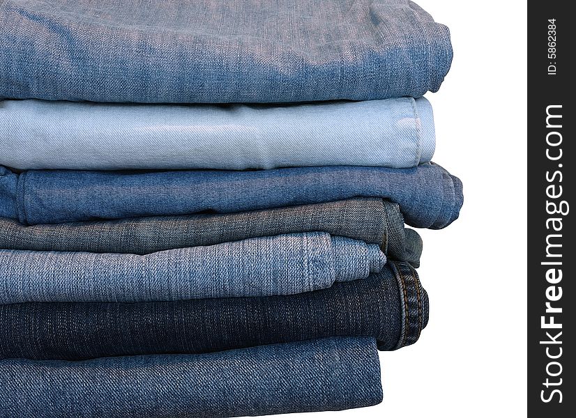 Stack of blue and black jeans over white with clipping path. Stack of blue and black jeans over white with clipping path