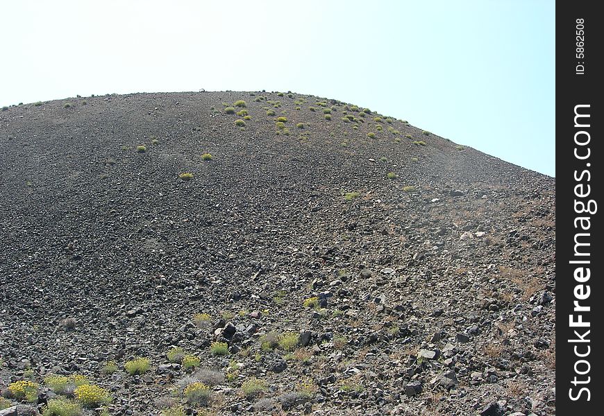 Inside the summit of a volcano with volcanic rock.