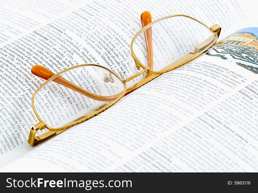 Glasses lying on an open book - close up. Glasses lying on an open book - close up