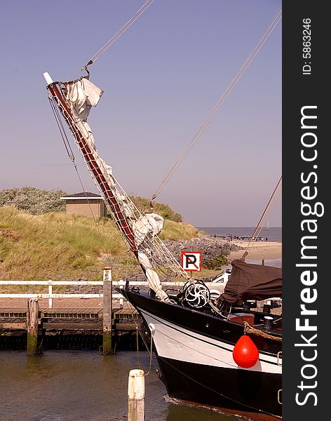 The bow of a  classic sailing ship in the entrance of a harbour