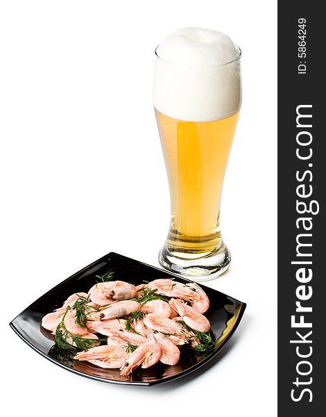 Beer in a glass and a dish with shrimps on a white background