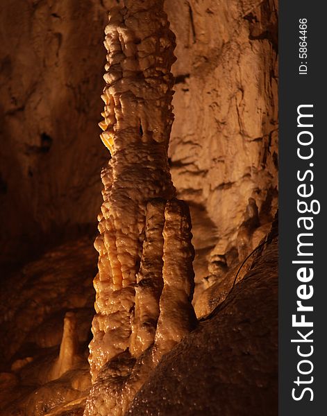 Tall unusual stalagmites and stalactites in the underground cavern in france, vertical