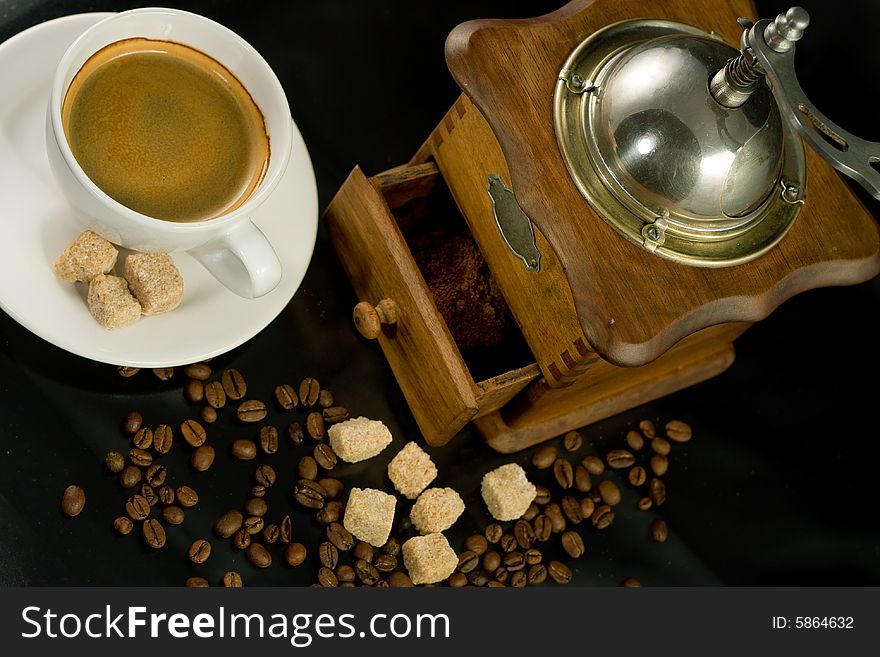 Nostalgic coffee mill, A cup of espresso, coffee beans and scoop beside it. Nostalgic coffee mill, A cup of espresso, coffee beans and scoop beside it