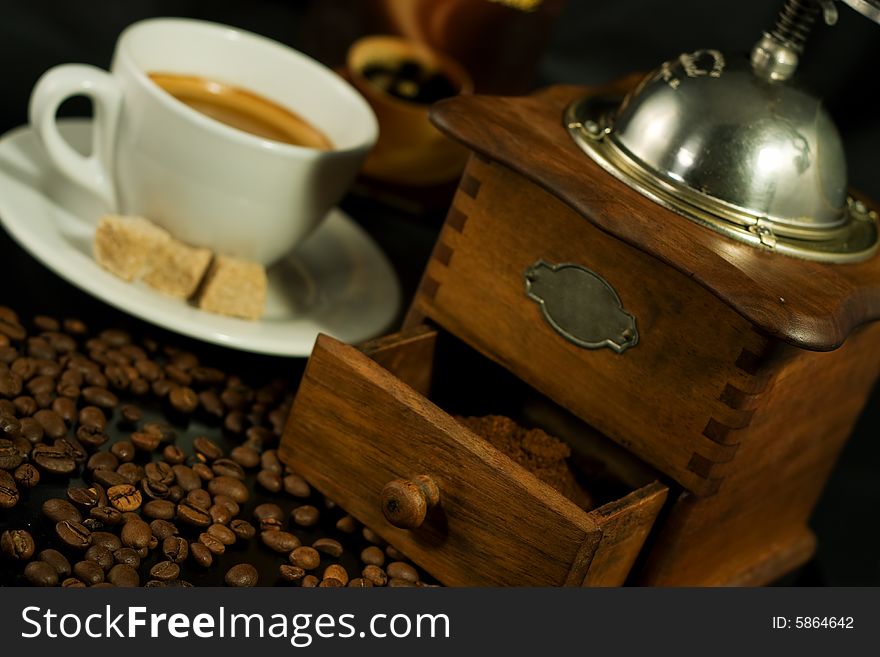 Nostalgic coffee mill, A cup of espresso, coffee beans and scoop beside it. Nostalgic coffee mill, A cup of espresso, coffee beans and scoop beside it