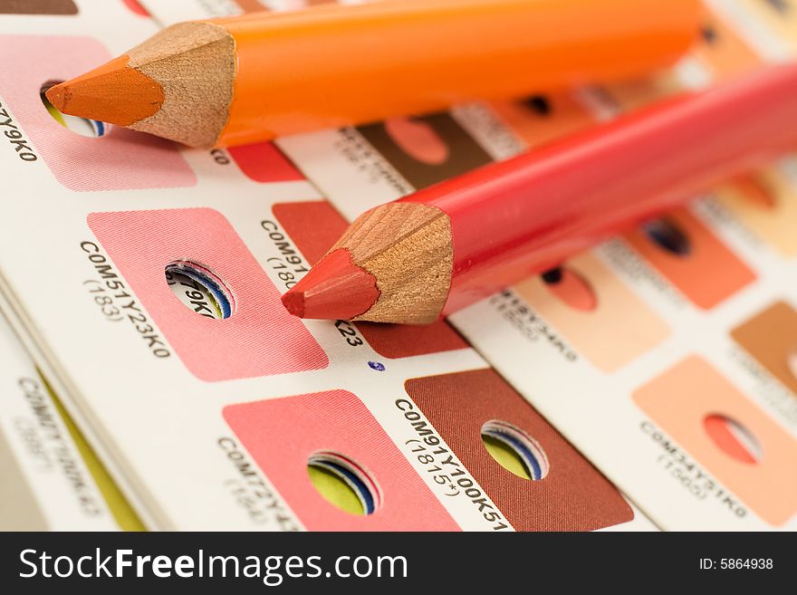 Orange and red pencils on cmyk color bars. Orange and red pencils on cmyk color bars