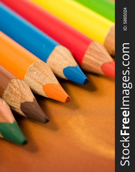 School and office articles: coloured pencils on brown background. School and office articles: coloured pencils on brown background