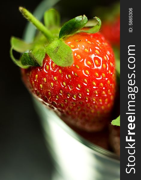 Strawberry in glass on black background. Strawberry in glass on black background