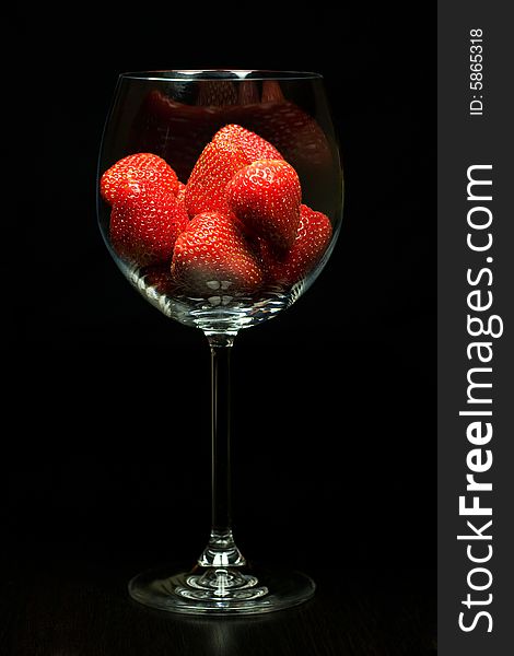 Strawberry in glass on black background