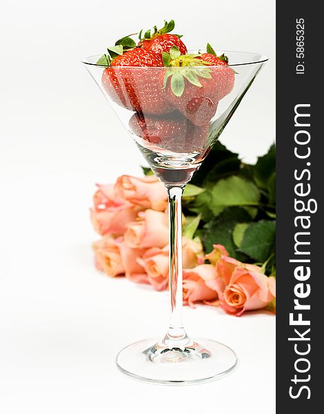 Romantic rose with strawberries in glass over white