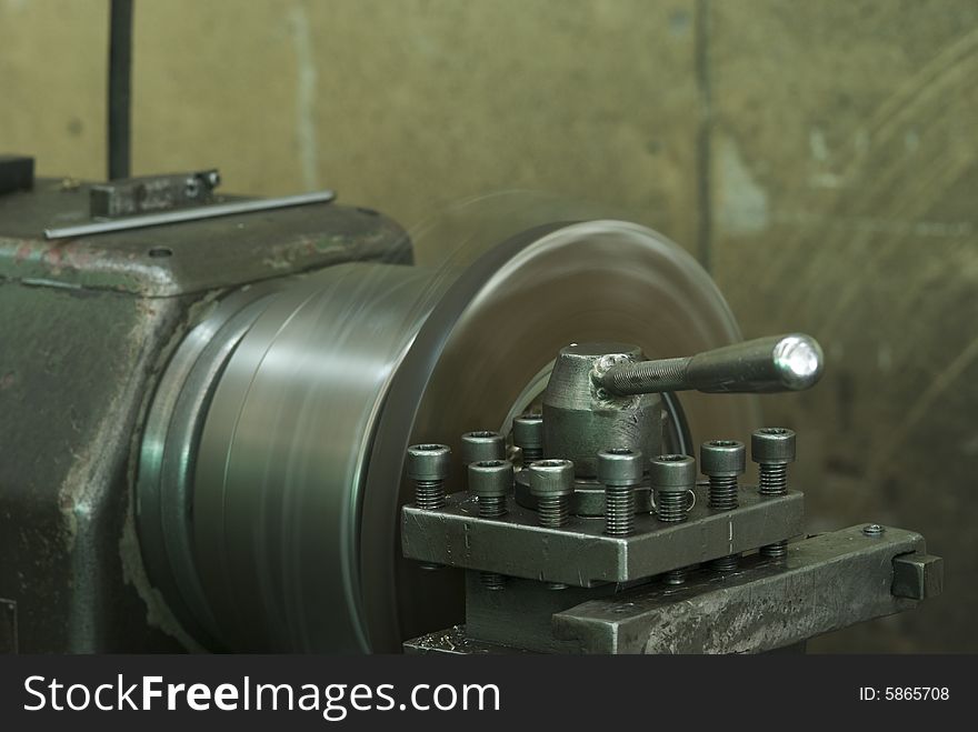 Steel lathe in production. Shallow depth of field with the control handle in focus.