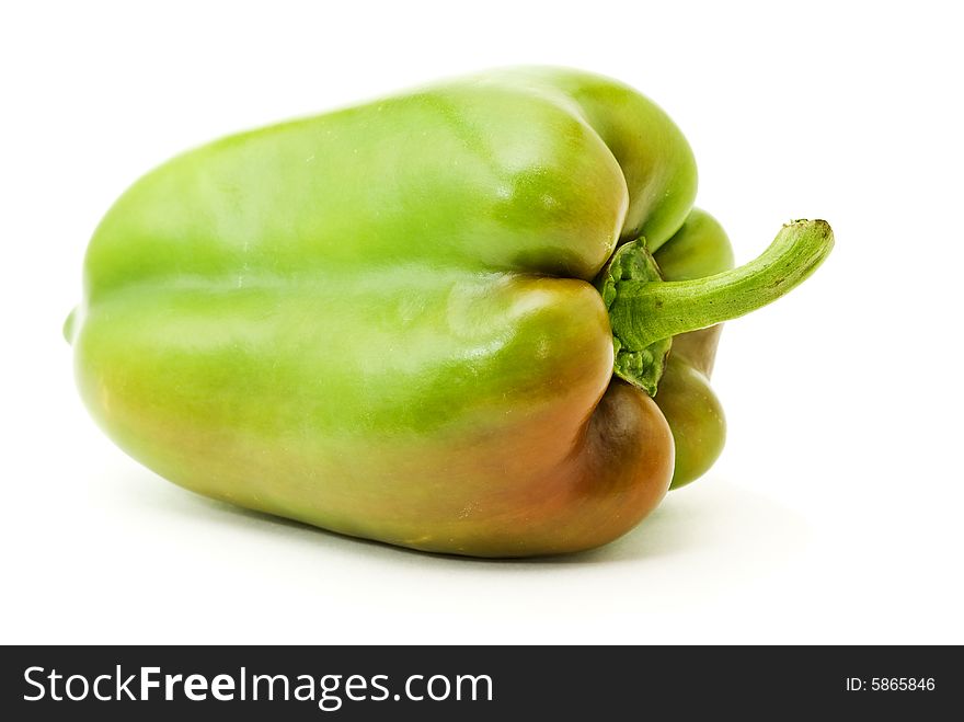 Green bell-pepper with red side over white background