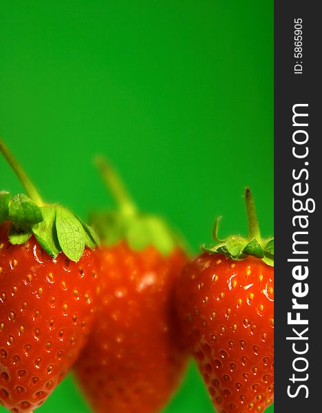 Close-up of strawberries in line on green background. Close-up of strawberries in line on green background