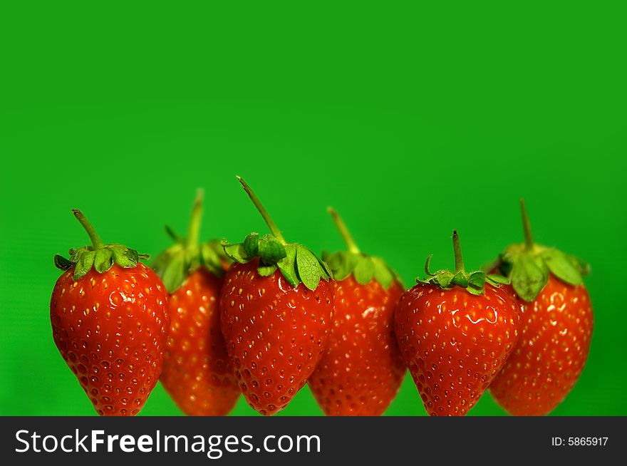 Strawberries in line on green background. Strawberries in line on green background