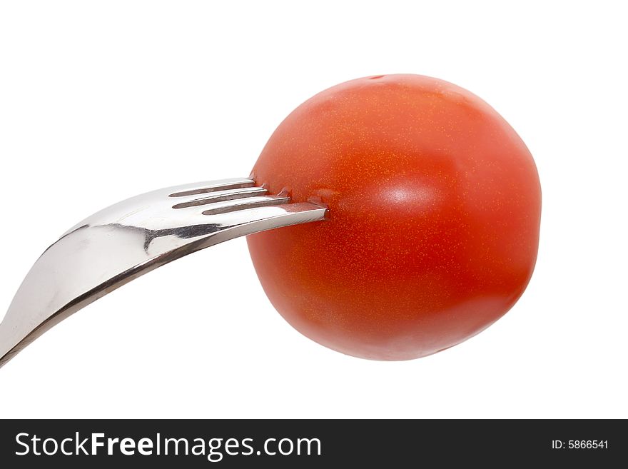 A tomato on a fork isolated on white