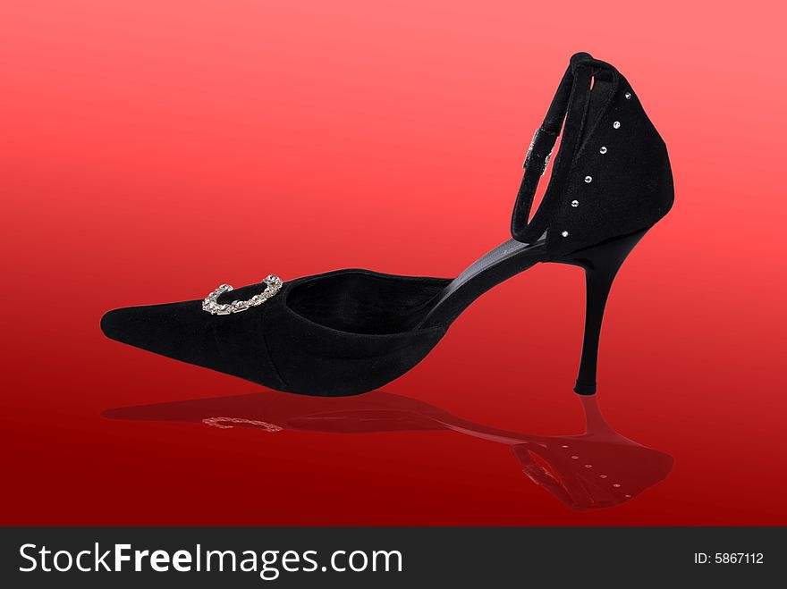 Elegant stiletto shoe with reflection on red background