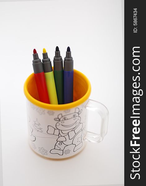 Red yellow green and blue marker in the mug on white background. Red yellow green and blue marker in the mug on white background