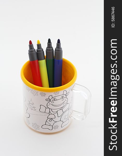 Mug with markers placed on white background