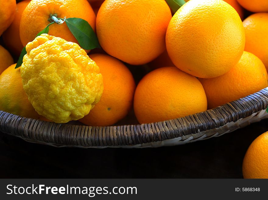 Assortment of fresh oranges and lemons in a wicker basket. Assortment of fresh oranges and lemons in a wicker basket