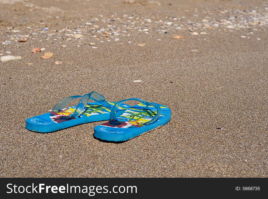 Image of a pair of beach shoes lying on the sand. Image of a pair of beach shoes lying on the sand