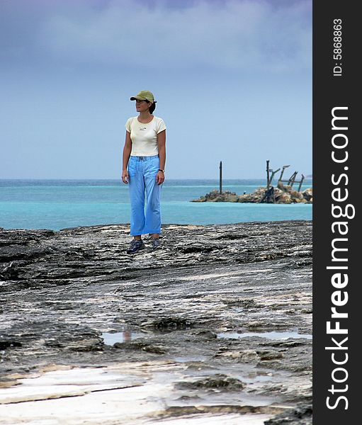 The girl on eroded ghost beach in Freeport on Grand Bahama Island, The Bahamas. The girl on eroded ghost beach in Freeport on Grand Bahama Island, The Bahamas.