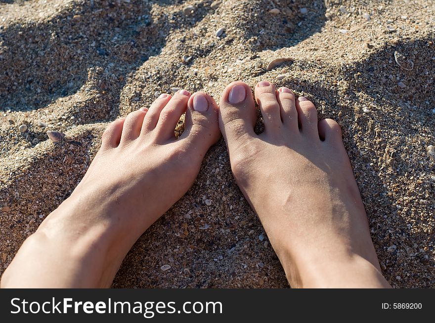 Image of the feet of a female lying in the sand. Image of the feet of a female lying in the sand