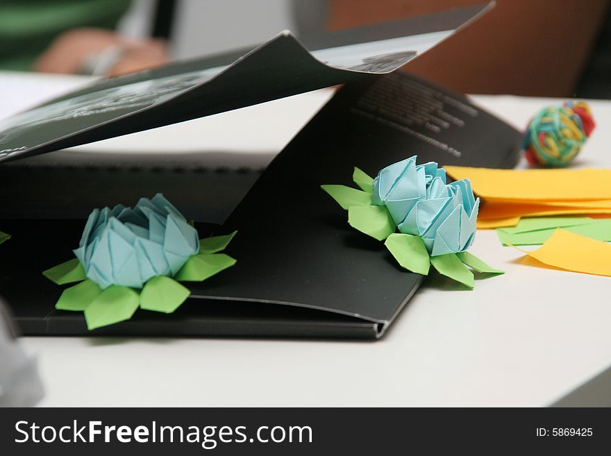 Two bright paper flowers on a black business folder. Two bright paper flowers on a black business folder