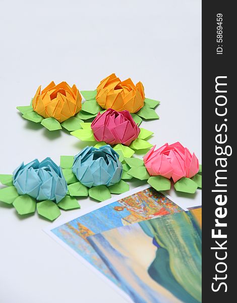 Six multicoloured paper flowers and a children pictures on a grey background. Six multicoloured paper flowers and a children pictures on a grey background