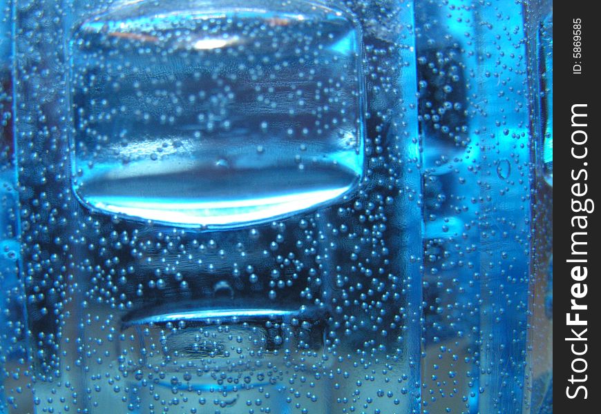Texture, lighting, bubbles, and water give the illusion of a sinking ice cube, in sparkling water.