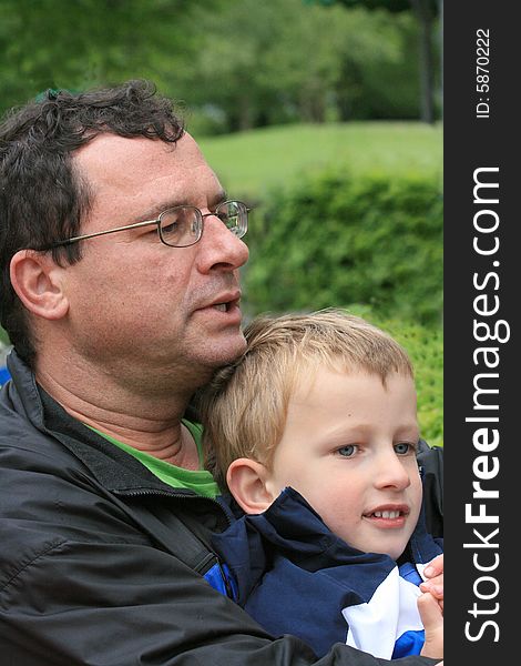 Father holding his young son in a park setting. Father holding his young son in a park setting