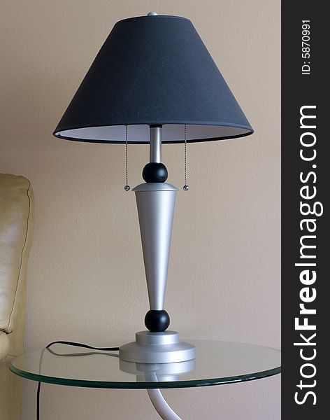 A moden lamp on a table inside a home. A moden lamp on a table inside a home.