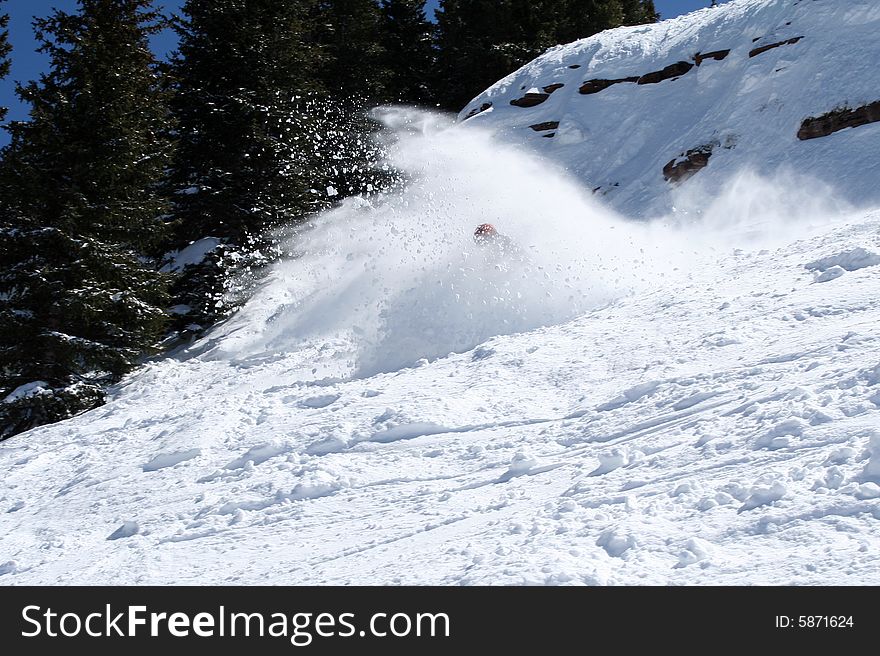 A rider falls down in the snow on a great powder day, after a big jump. A rider falls down in the snow on a great powder day, after a big jump